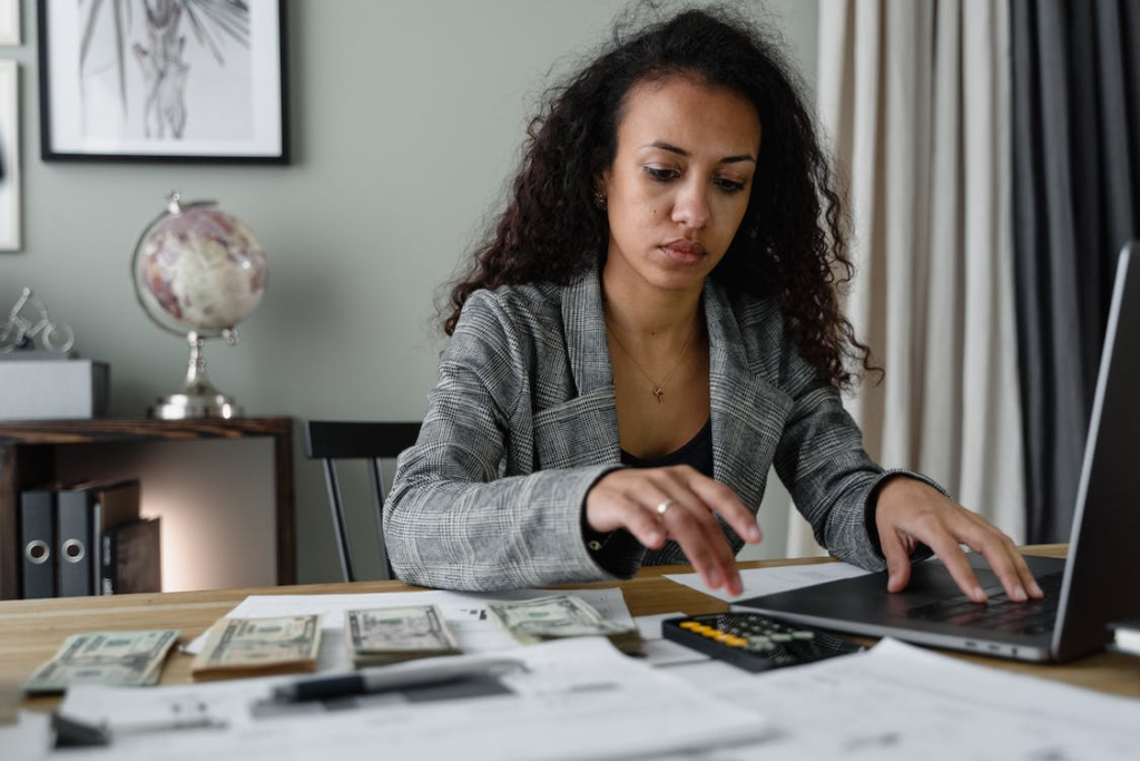 A woman managing her money while using a laptop