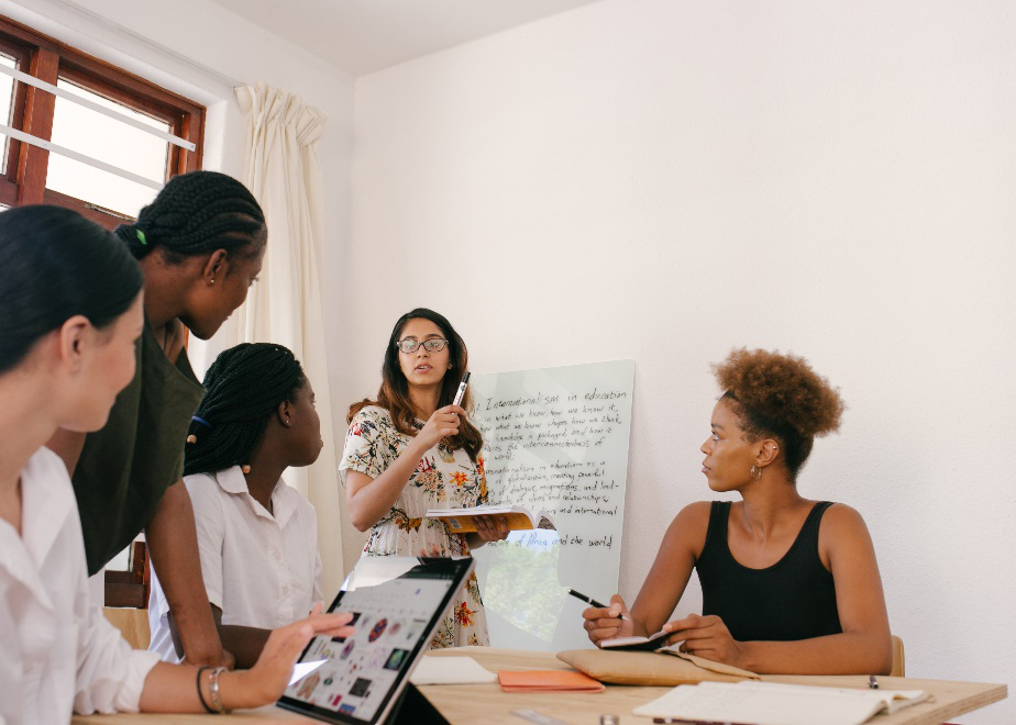 A bespectacled woman presenting an idea to her peers