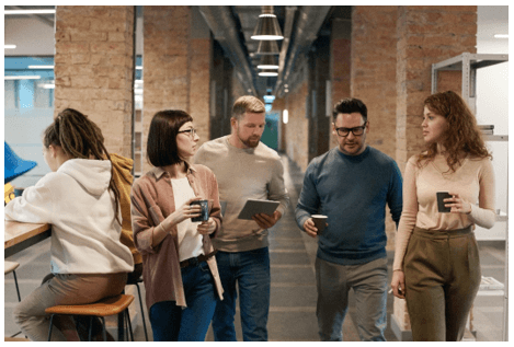 People walking with coffees in an office